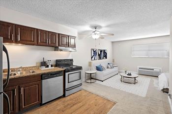 A modern kitchen with dark wood cabinets and stainless steel appliances.